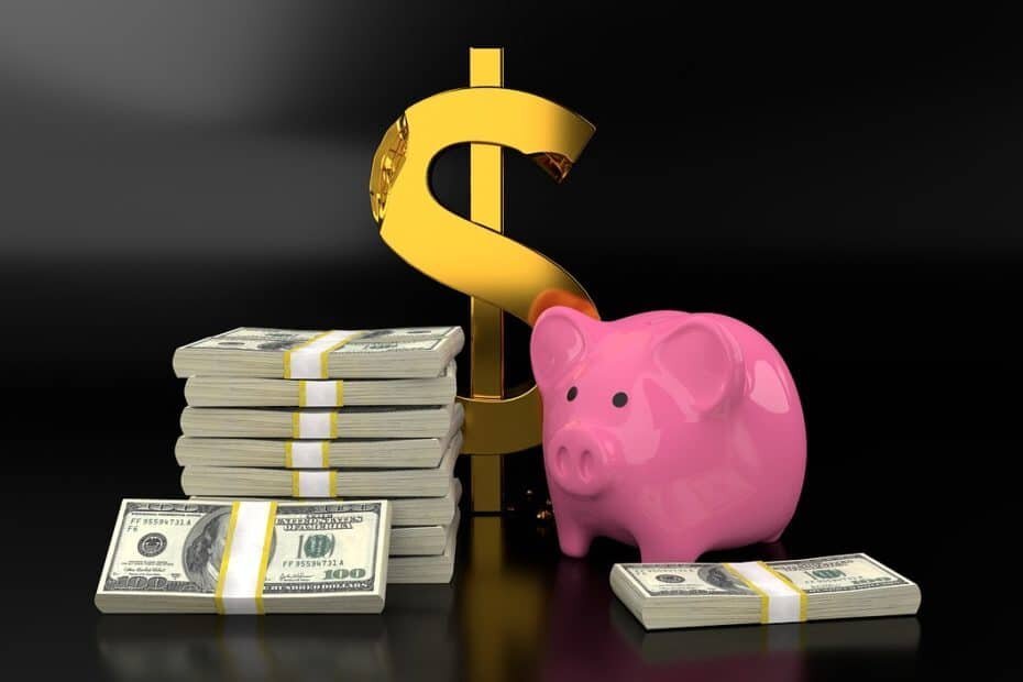 Pink piggy bank with large gold dollar sign and stacks of $100-bills on a black background