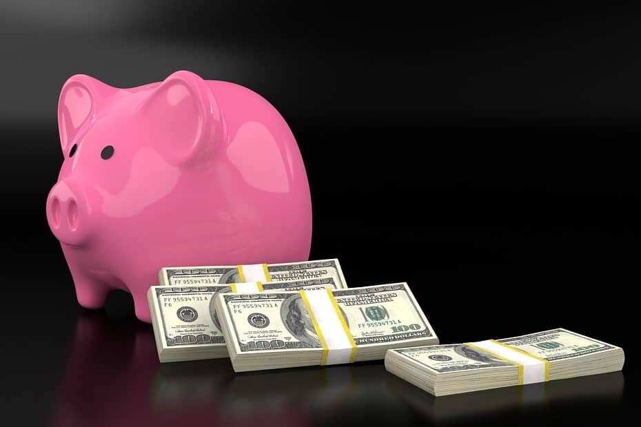 Pink piggy bank with 4 bundles of $100 bills, on a black background