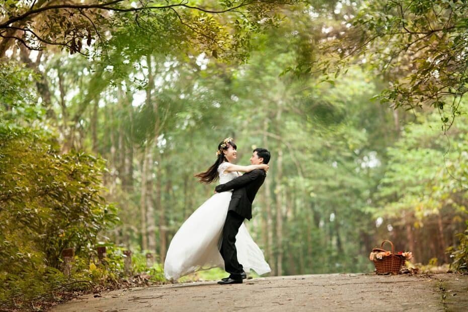 Bride and groom embracing on a path in the woods